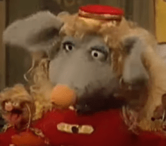 Pepe and Seymour in their bellhop outfits, blonde wigs, and pig noses.